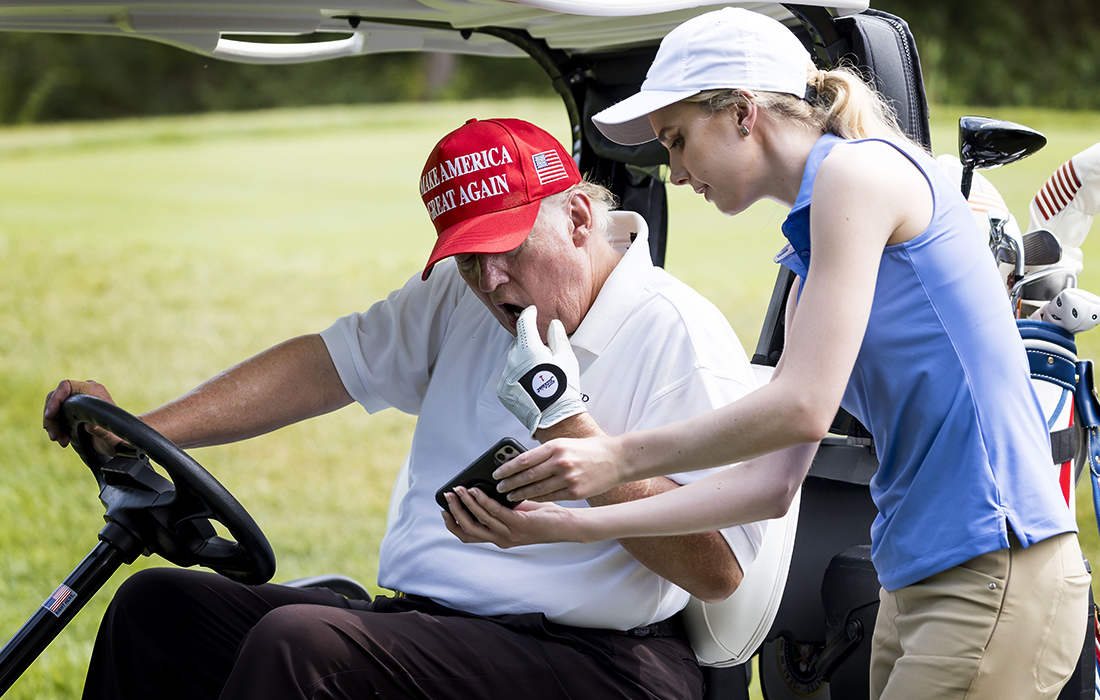 Сотрудник показывает Дональду Трампу опрос, сравнивающий его популярность с бывшим вице-президентом США Майком Пенсом во время турнира по гольфу в Нью-Джерси