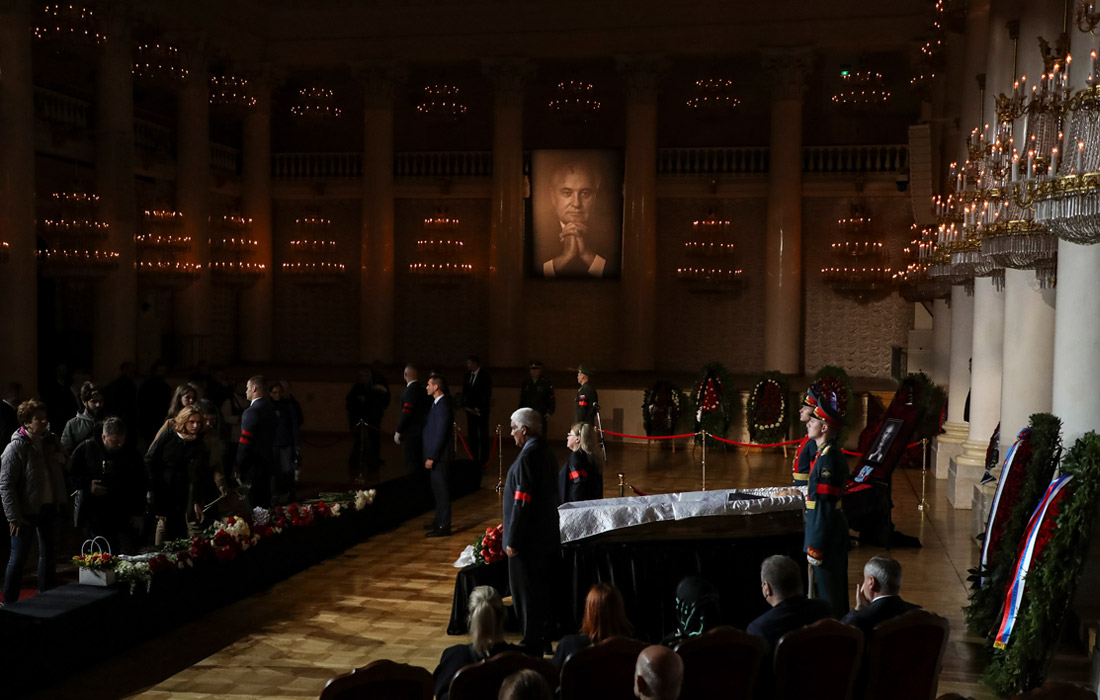 В зале множество венков с траурными лентами