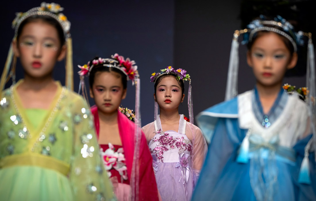 Модели представляют творения из линии детской одежды во время Китайской недели моды в Пекине