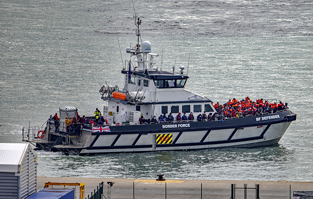 Британские пограничники и военнослужащие сопровождают мигрантов к берегу в районе Дувра после того, как они пересекли Ла-Манш
