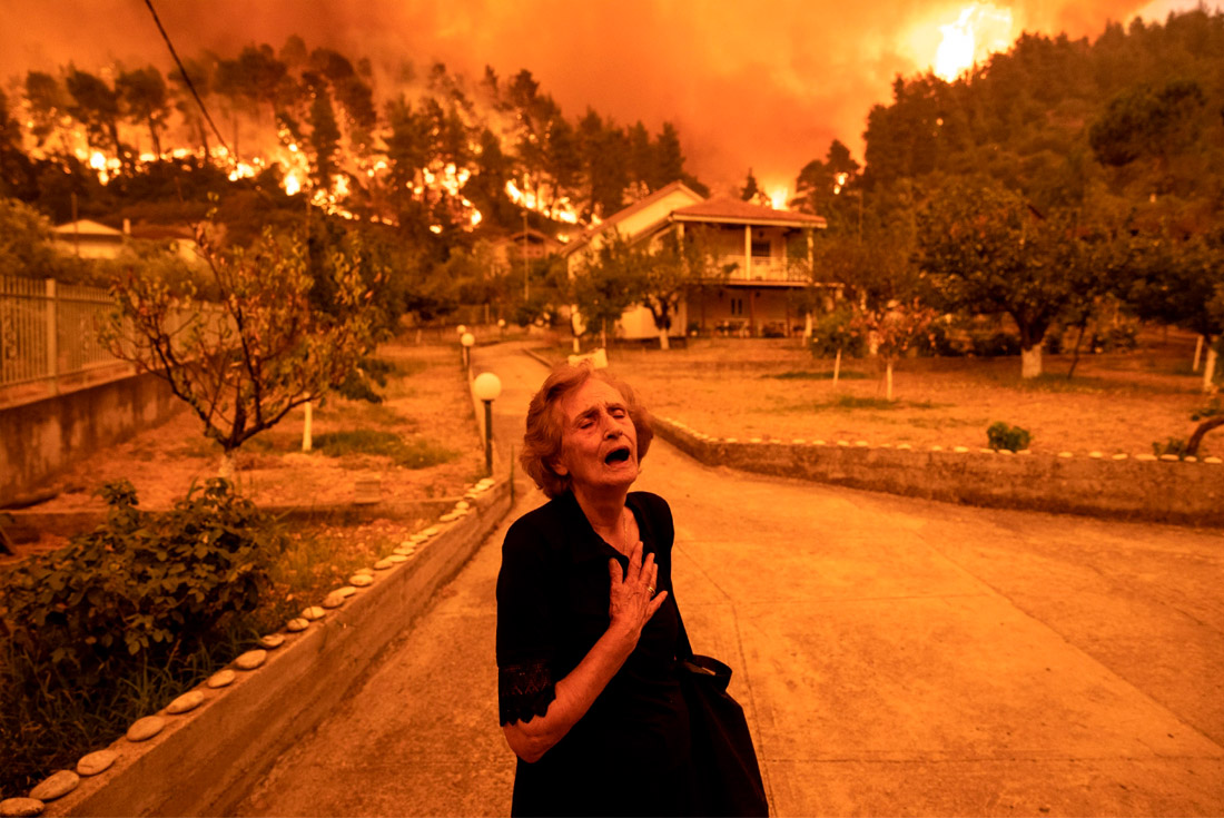 Лауреат премии "Фотография года". Реакция пожилой женщины на лесной пожар, приближающийся к ее дому на острове Эвия (Греция).