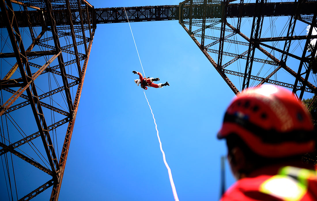 76-летний пожарный Эктор Чакон спустился с моста, чтобы поделиться подарками с детьми из бедного района Гватемалы