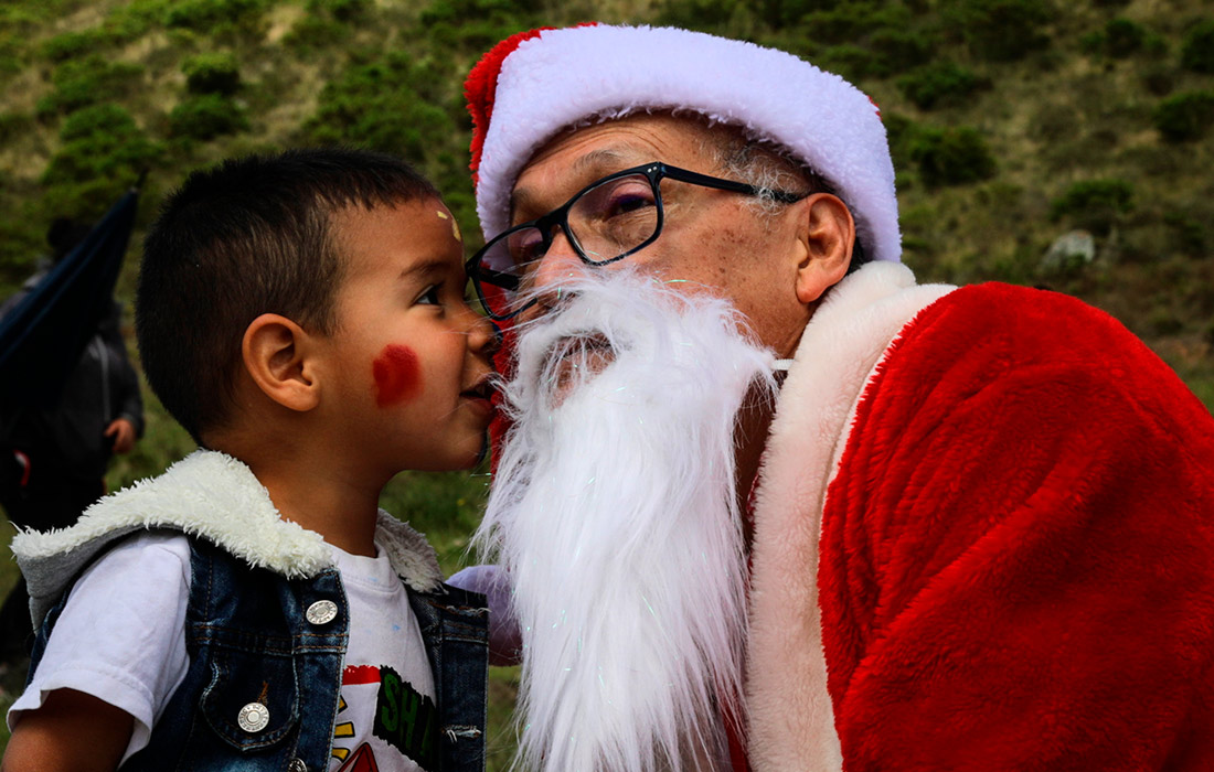 Колумбийский Санта посещает детей беженцев на окраине Боготы
