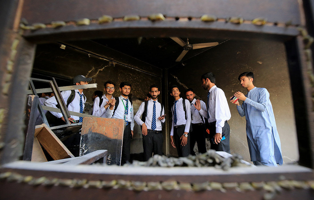 Студенты посещают сгоревшее здание Радио Пакистана в Пешаваре