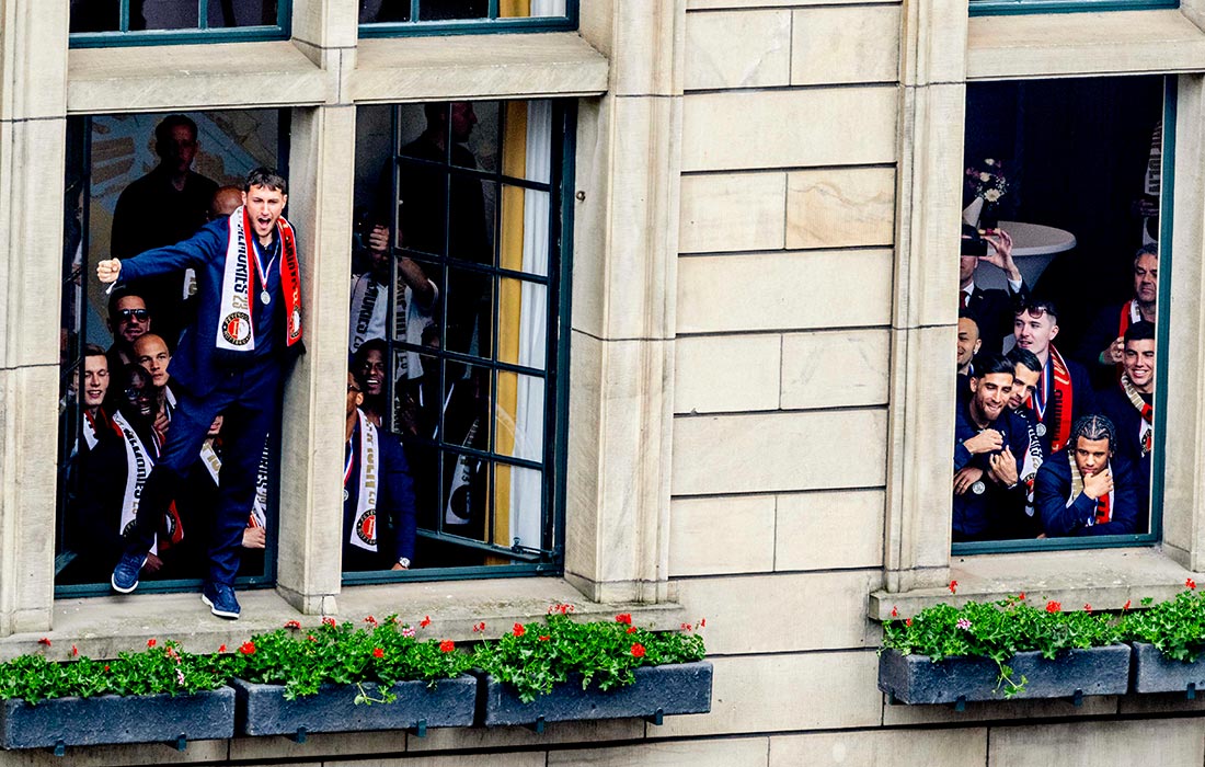 Игроки "Фейеноорда" приветствуют фанатов из окна ратуши в Роттердаме после победы в национальном чемпионате