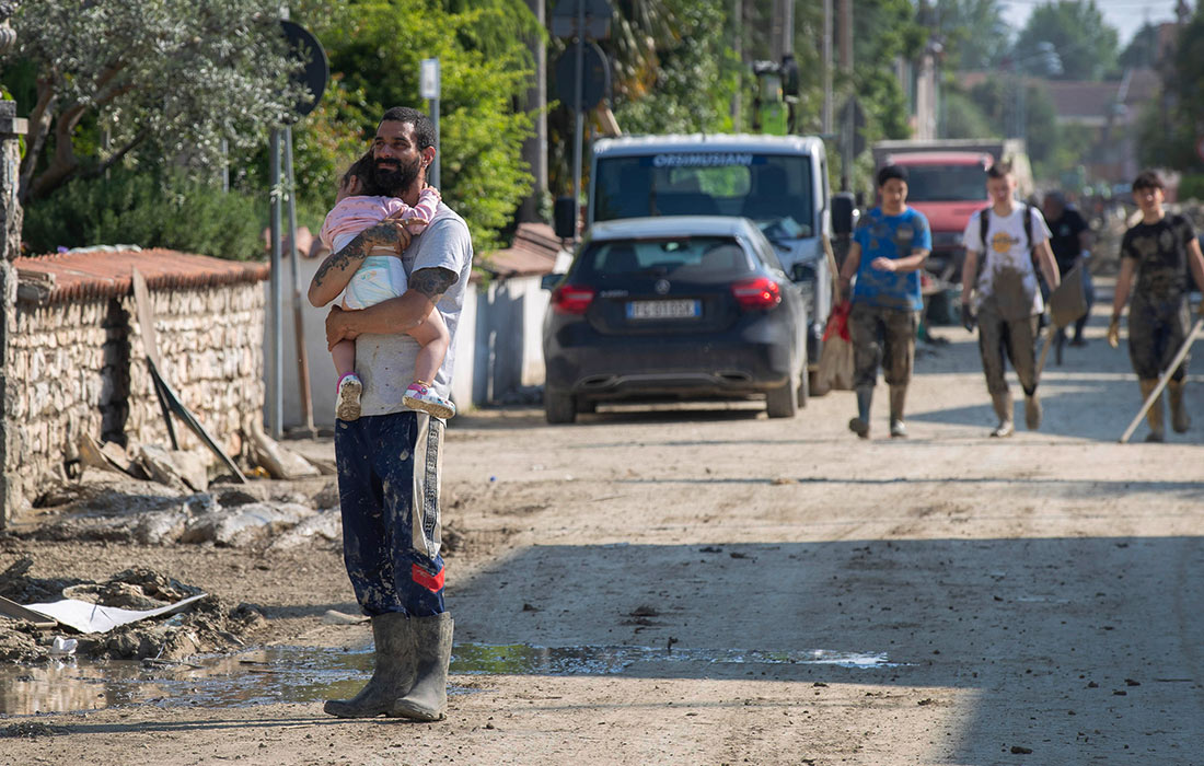Волонтеры расчищают грязь после наводнения и оползня на севере Италии