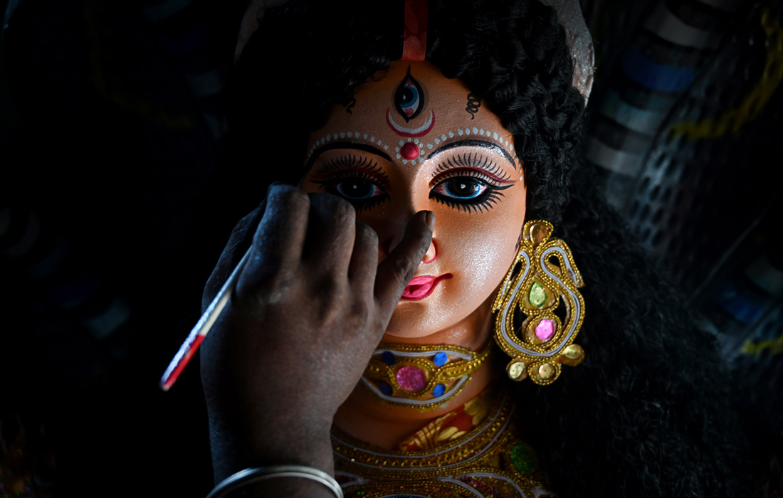 Художник добавляет последние штрихи к идолу индуистской богини в Нойде, Индия