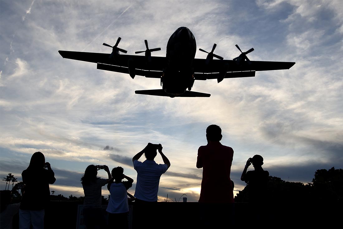Люди фотографируют приближающийся тайваньский военный самолет C-130 Hercules в аэропорту Суншань в Тайбэе