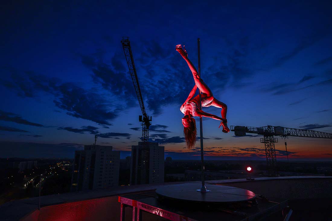 Танцовщица исполняет танец на пилоне на крыше в Берлине