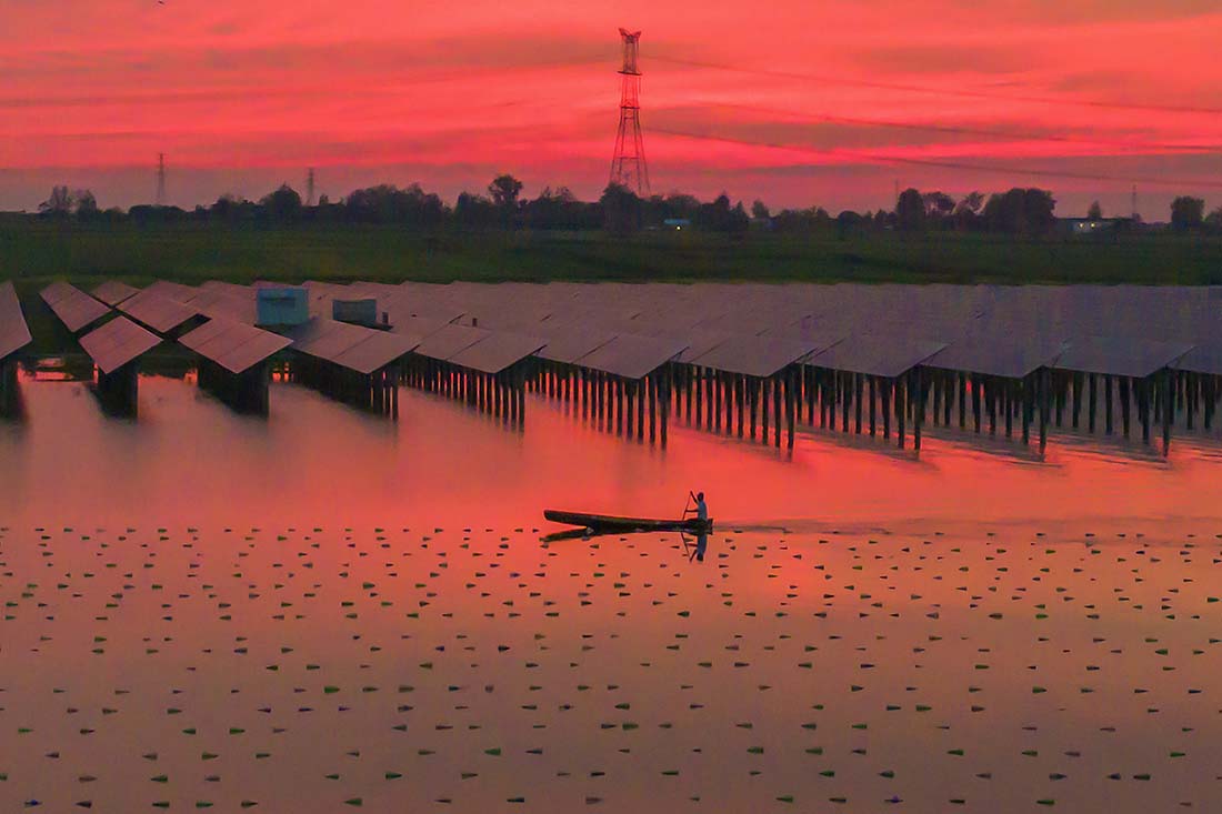 Рабочий на ​​гибридной фотоэлектрической электростанции, в Суцяне, Китай