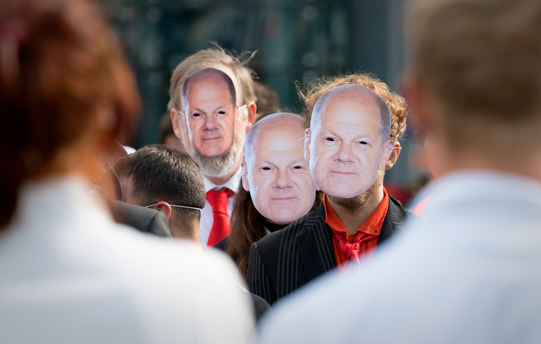 Демонстранты в масках Олафа Шольца во время марша протеста группы по защите климата