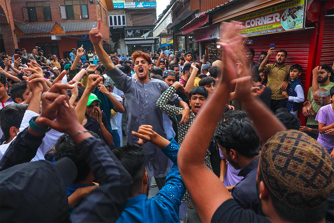 Мирваиз Моулви Умар Фарук, главный имам Кашмира (за кадром), провел пятничную проповедь в мечети Джамия Масджид после четырехлетнего перерыва, вызванного домашним арестом