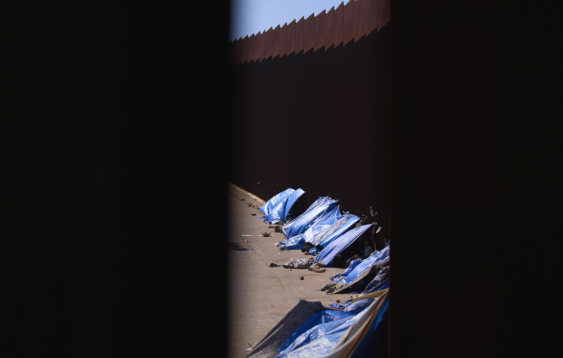 Мигранты устанавливают палатки у стены на южной границе США с Мексикой в Сан-Диего