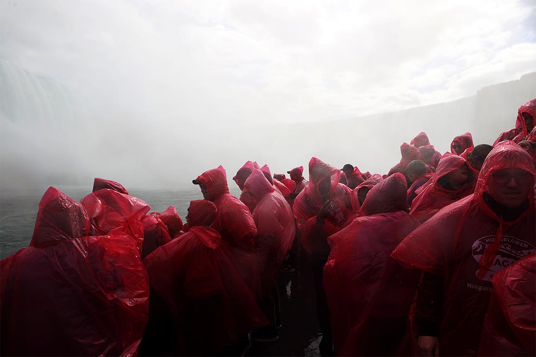 Туристы на лодке у Ниагарского водопада, Онтарио, Канада.