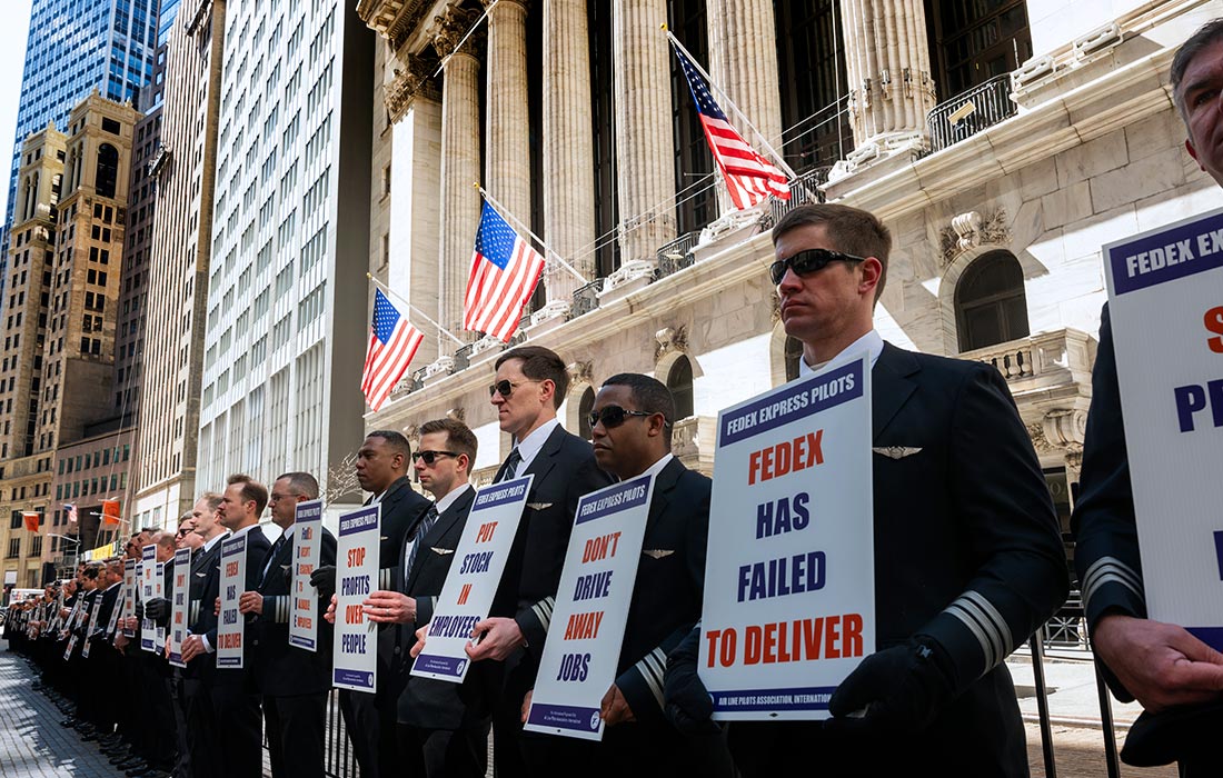 Пилоты FedEx участвуют в молчаливом протесте возле Нью-Йоркской фондовой биржи. В преддверии публикации доходов FedEx за третий финансовый квартал пилоты были разочарованы отсутствием нового контракта с руководством FedEx.