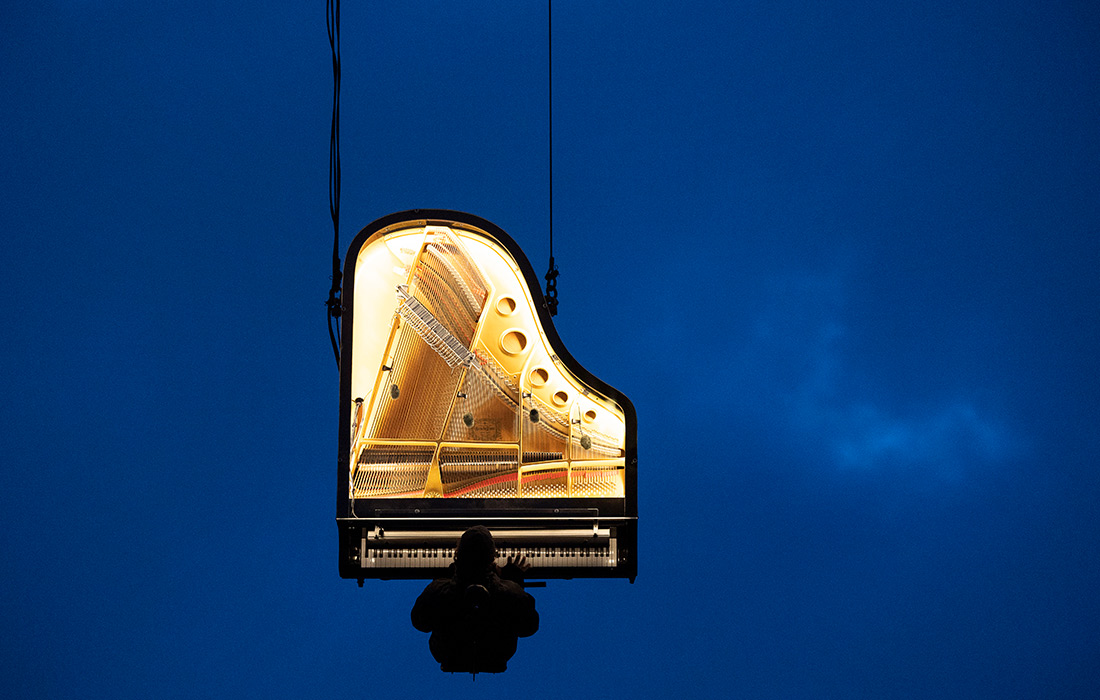 Музыкант Ален Рош играет на подвешенном фортепиано в Мюнхене