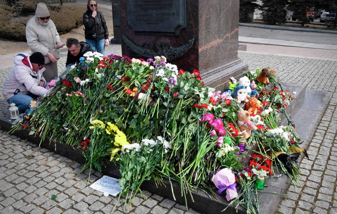 Люди возлагают цветы к стеле "Владивосток - город воинской славы"