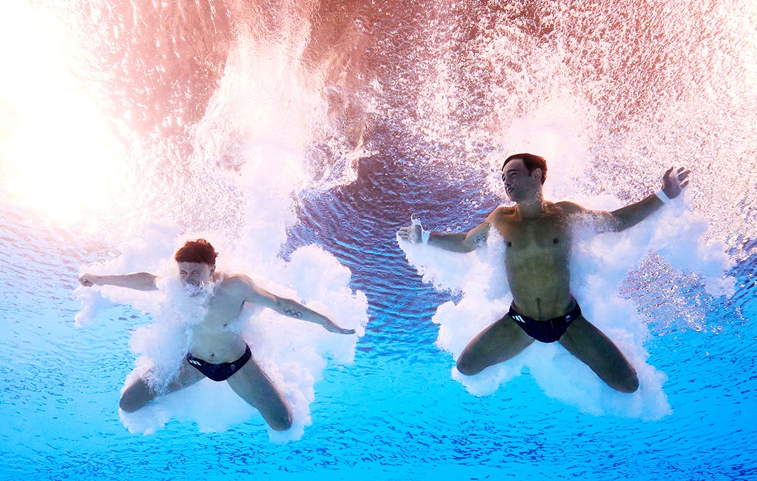 Томас Дейли и Ноа Уильямс из сборной Великобритании соревнуются в финале соревнований по синхронным прыжкам с вышки