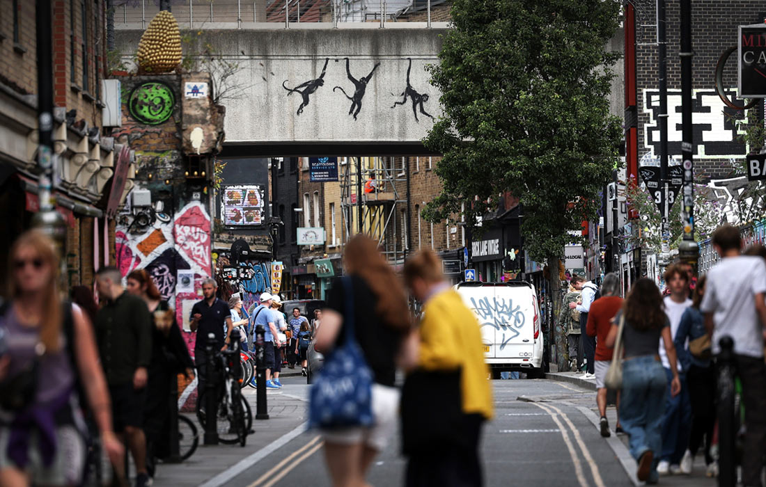 Силуэты обезьян, висящих на железнодорожном мосту в районе улицы Брик-лейн в восточной части Лондона
