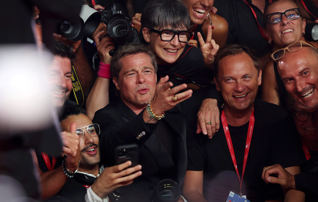 Брэд Питт общается с фотографами во время Венецианского международного кинофестиваля