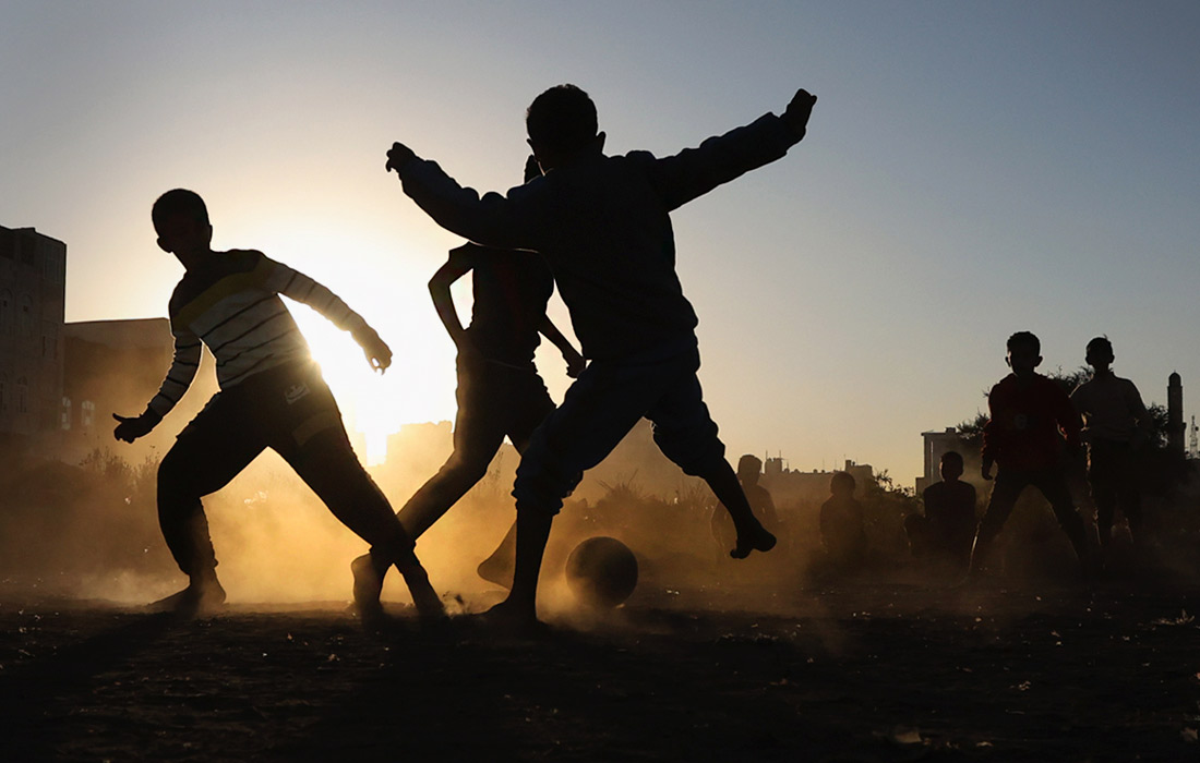 Дети играют в футбол на закате в Сане, Йемен