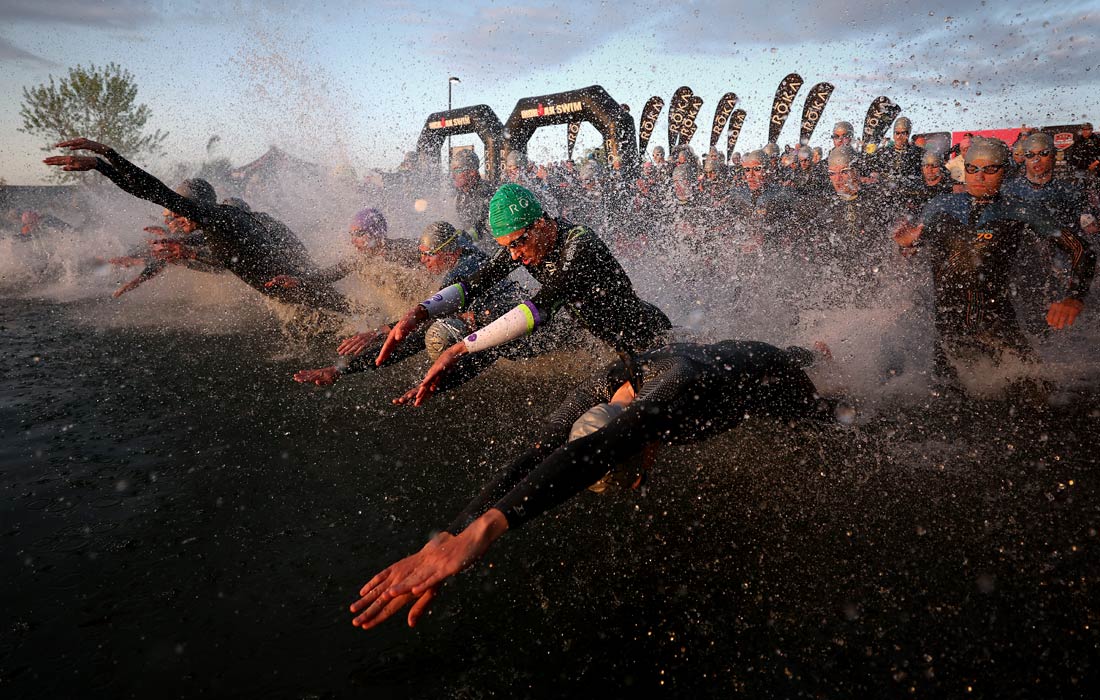 Мужчины стартуют в заплыве на Чемпионате мира по триатлону серии Ironman 70.3 в Сент-Джордже, штат Юта, США