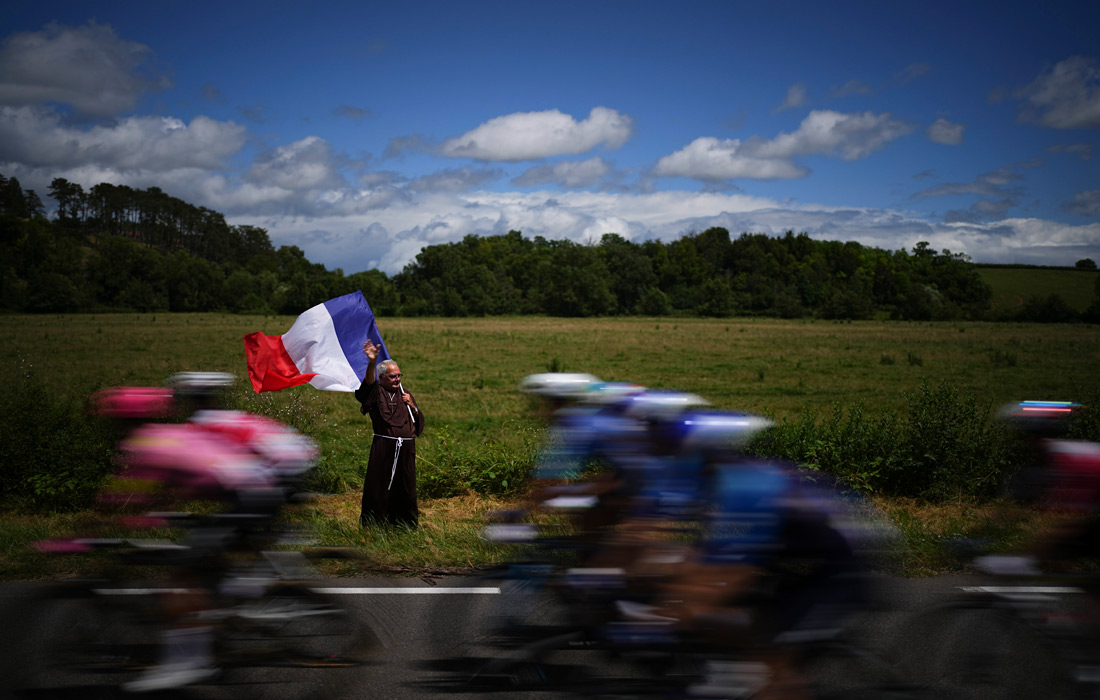 Мужчина приветствует участников велогонки "Тур де Франс" в Дижоне