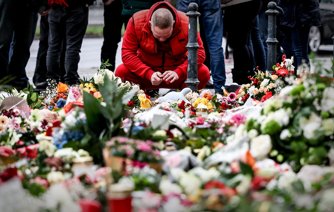 Жители немецкого Магдебурга несут цветы к стихийным мемориалам в память о жертвах нападения на рождественскую ярмарку