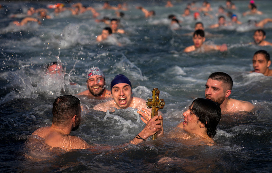 Верующие православной церкви во время церемонии ныряния за деревянным крестом в канун Рождества в Стамбуле