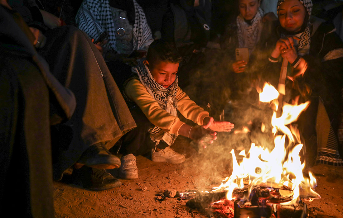 Израиль освободил более 600 палестинских заключенных в рамках сделки с ХАМАС. На фото: местные жители греются у костра, ожидая заключённых, освобожденных из израильских тюрем.