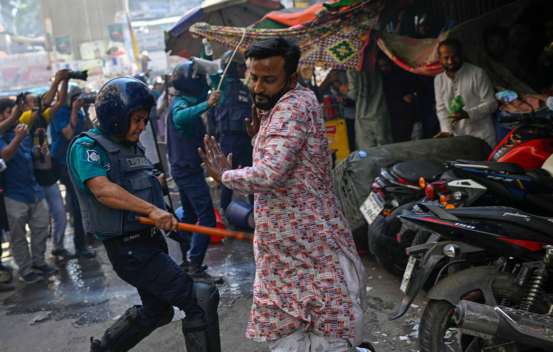 Полицейские используют дубинки для разгона сторонников запрещенной исламистской группировки возле мечети в Дакке, Бангладеш