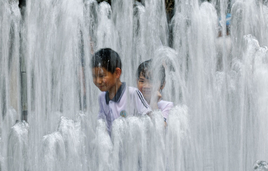 Дети спасаются от жары в фонтане, Шанхай