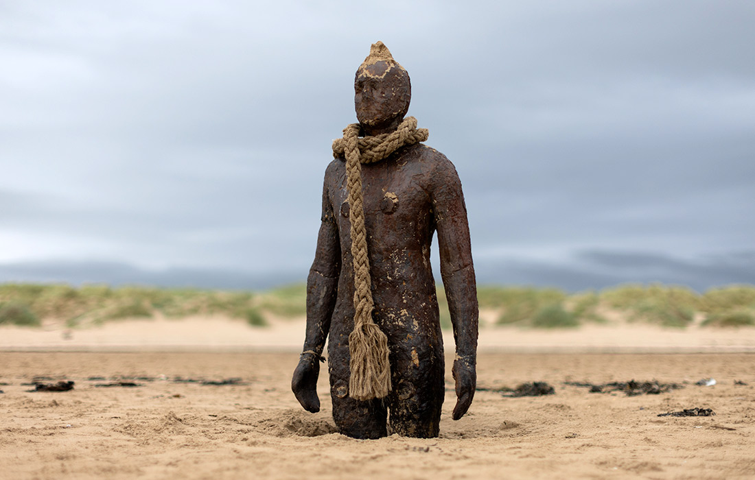 Скульптурная инсталляция "Другое место" художника Энтони Гормли на пляже Кросби в Великобритании