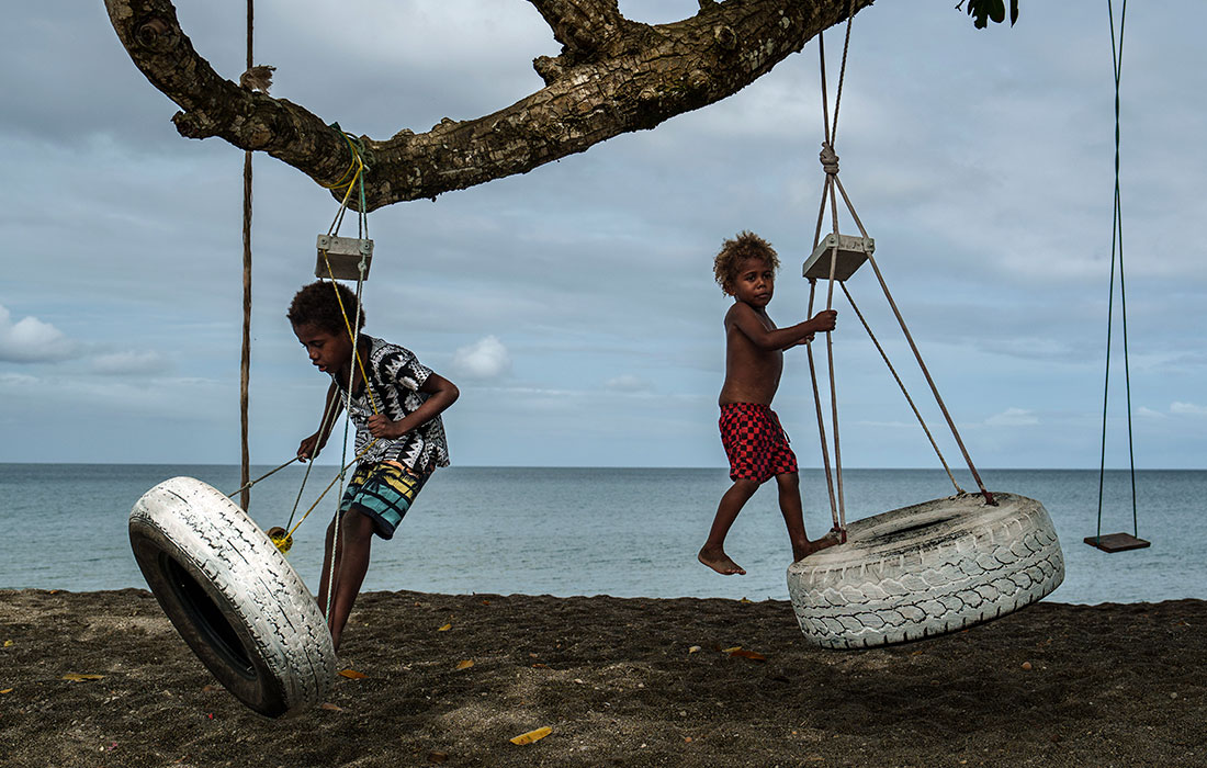 Дети играют на пляже в Меле, Вануату