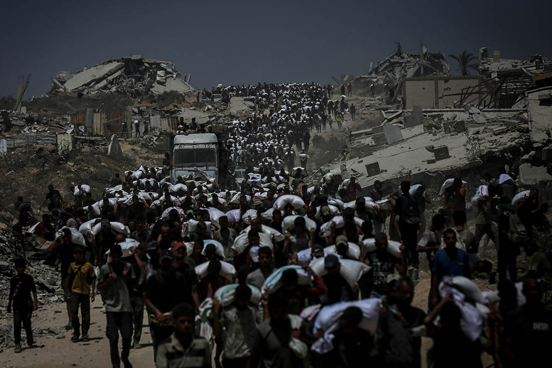 Жители Газы несут продукты, сброшенные израильтянами с воздуха