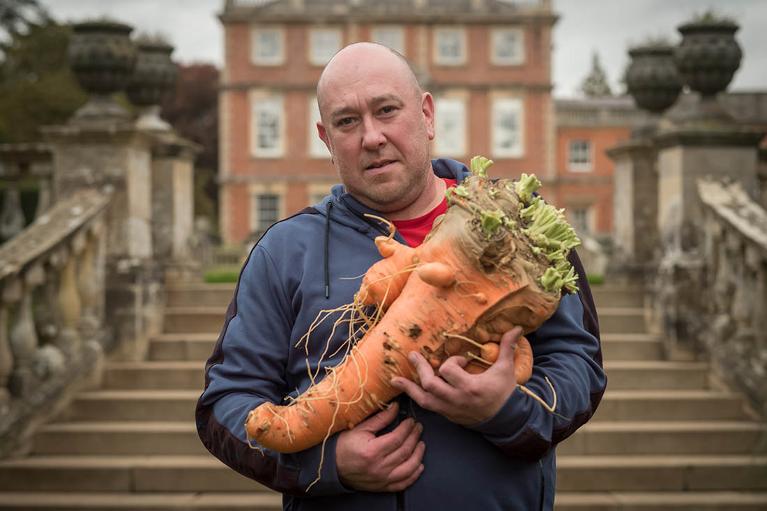 Фермер и выращенная им гигантская морковка на ежегодной выставке в Рипоне, Англия