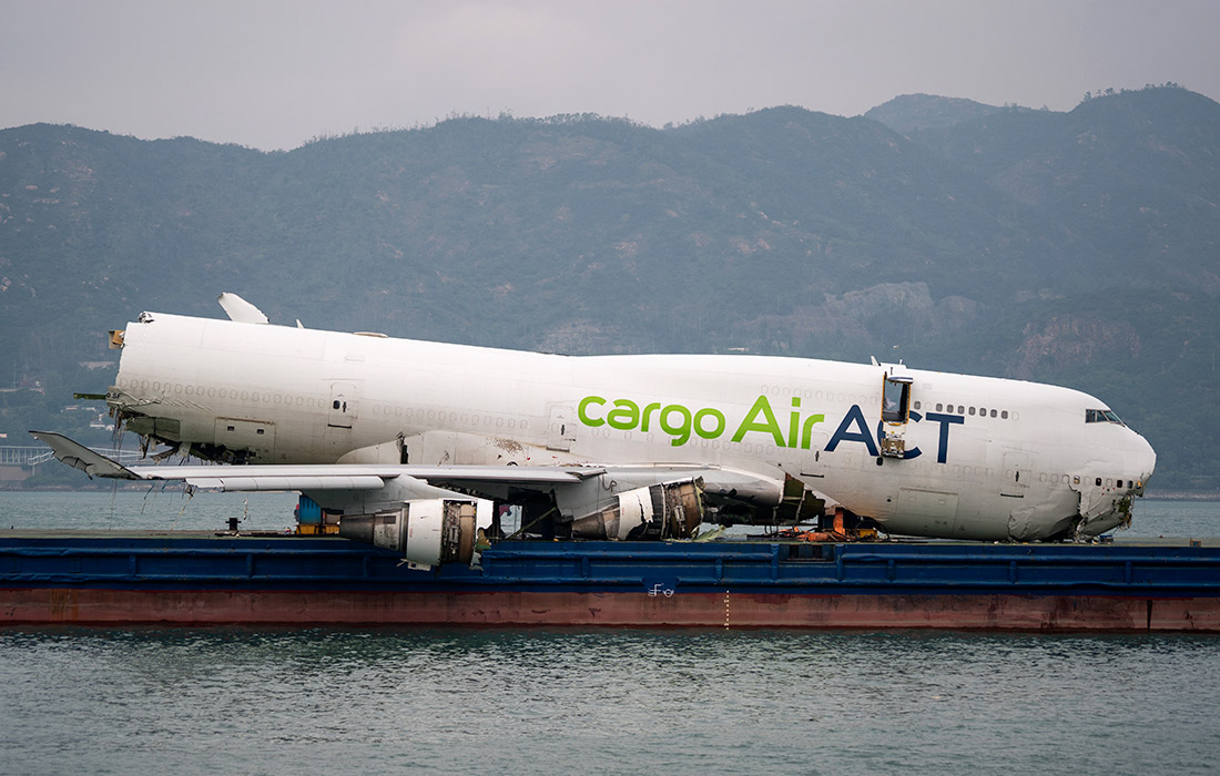 Фюзеляж выкатившегося в море самолета погрузили на баржу для эвакуации в Гонконге