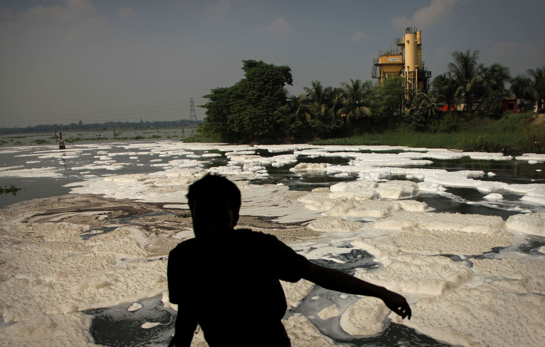 Токсичная пена от промышленных отходов на реке в Дакке, Бангладеш