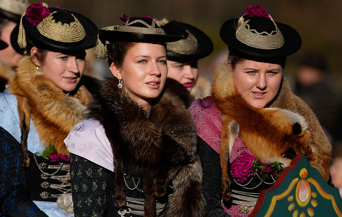 Девушки в национальных костюмах на конном параде в честь святого Леонарда в Баварии