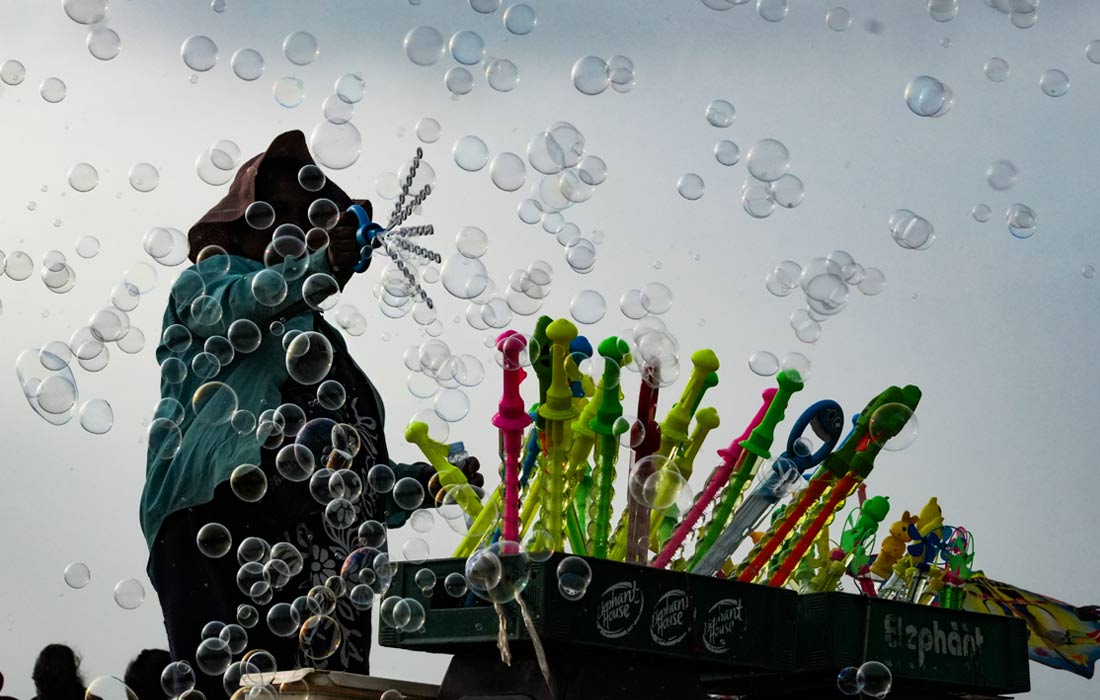 Продавец мыльных пузырей на пляже в Коломбо, Шри-Ланка