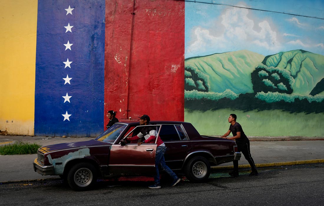 Жители Каракаса толкают заглохший автомобиль, Венесуэла