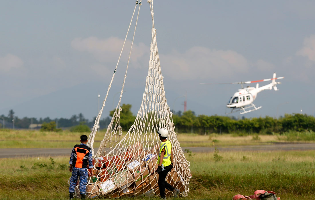 Доставка еды и гуманитарной помощи на вертолетах в пострадавшие от наводнения районы Индонезии