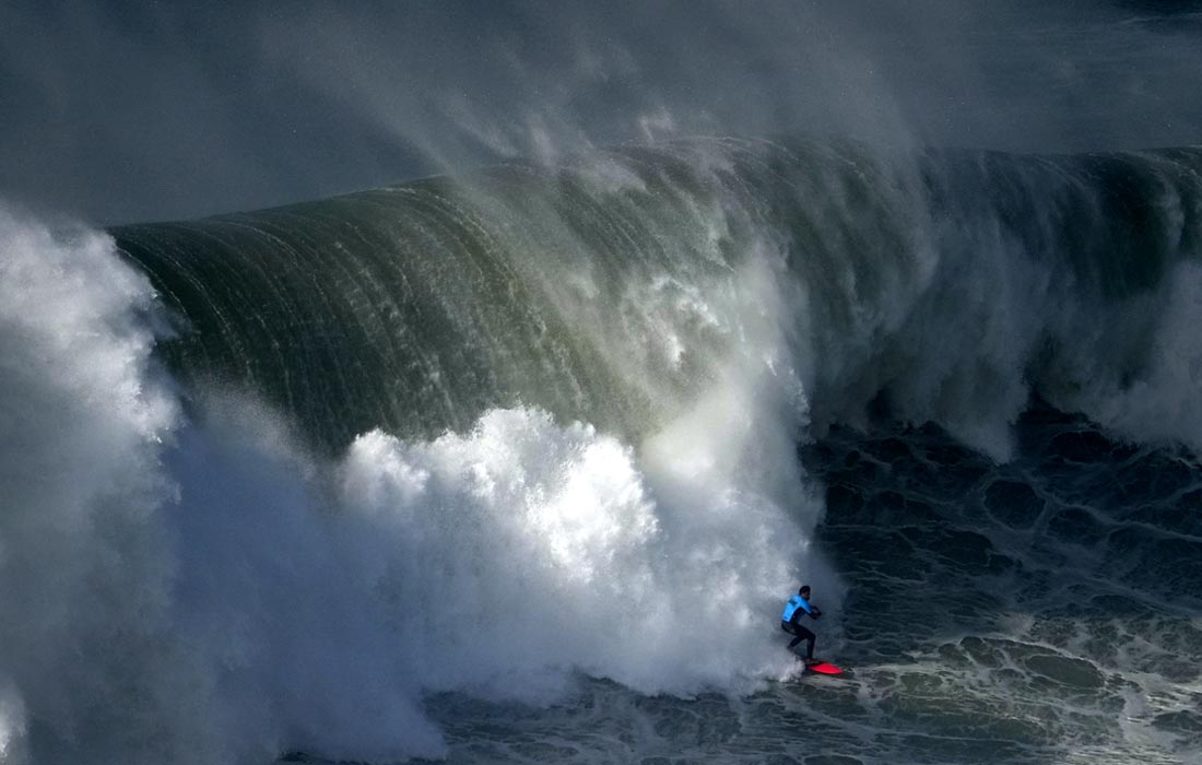 Серфинг во время сезона больших волн в португальском Назаре