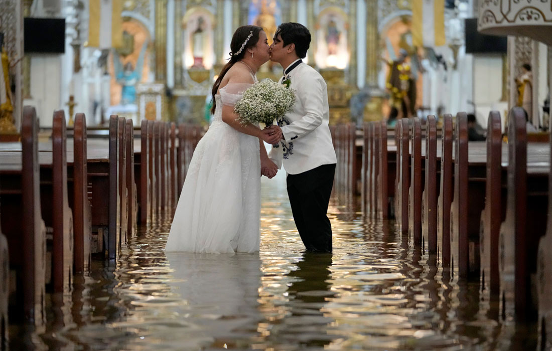 В конце июля супертайфун "Гаеми" привел к масштабному наводнению на Филиппинах. Более 20 человек погибли и не менее 15 получили ранения. На фото: молодожены в затопленной церкви в Малолосе.