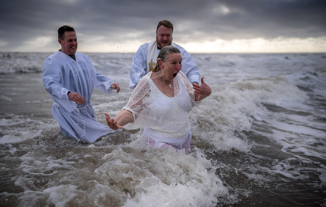 Крещение в Северном море на пляже Бридлингтона, Англия