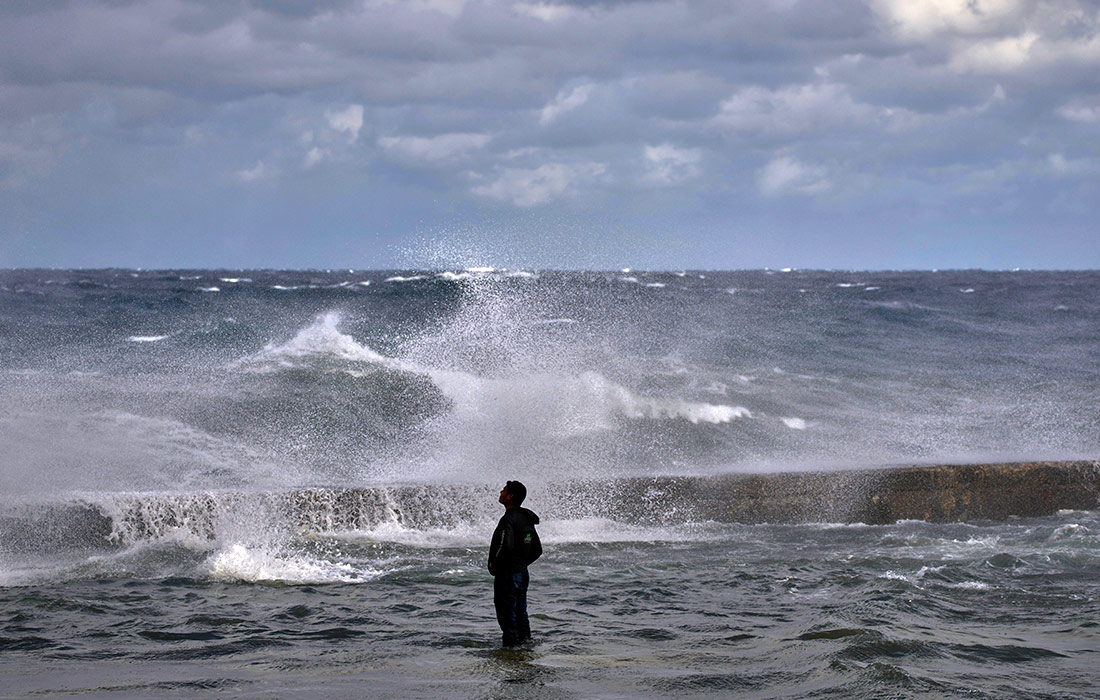 Мужчина наблюдает за волнами в Гаване, Куба