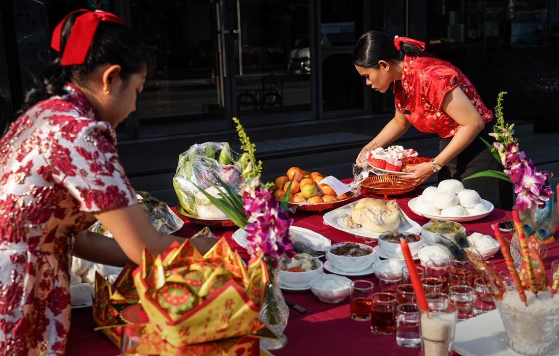 Члены тайско-китайской семьи приносят подношения предкам и духам умерших в Бангкоке