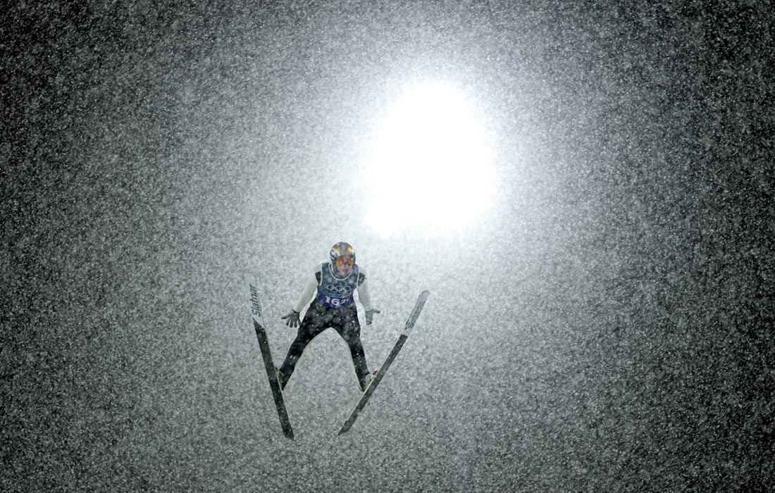 Словенец Домен Превц совершает прыжок на лыжах с трамплина