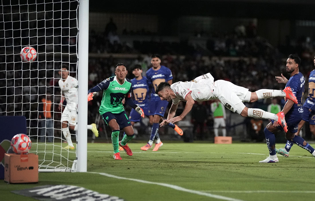 Нападающий "Толуки" Паулиньо забивает третий гол своей команды в ворота "Пумас" во время матча мексиканской футбольной лиги в Мехико