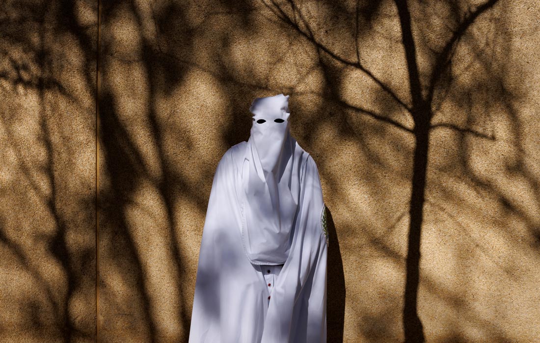 Кающийся член братства La Paz в Севилье, Испания